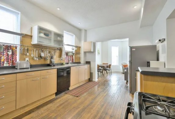 Kitchen with light wood cabinets, gas range, dishwasher, stainless refrigerator and hardwood floors